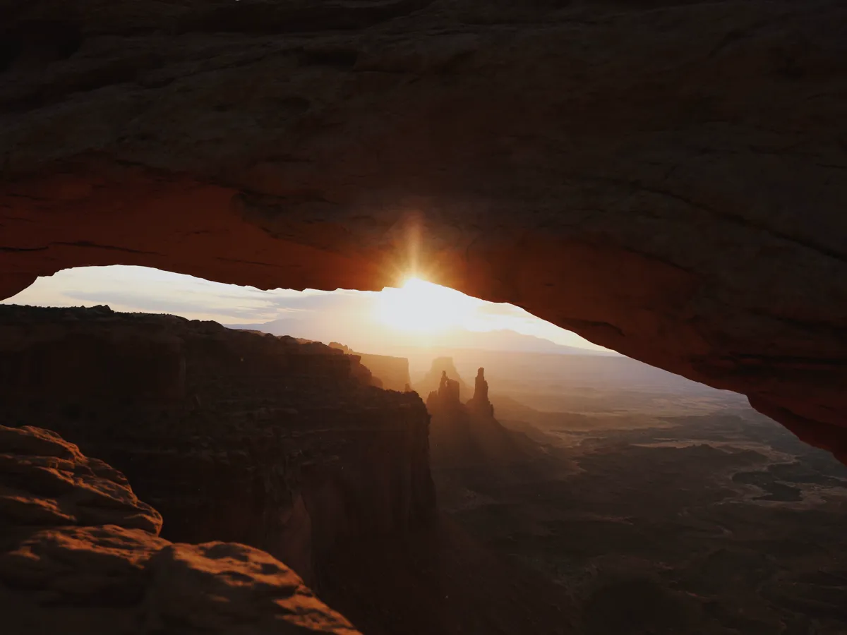 Wide canyon landscape lit by low morning sun with long shadows across the rock